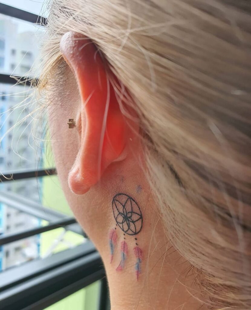 A behind-the-ear dream catcher tattoo