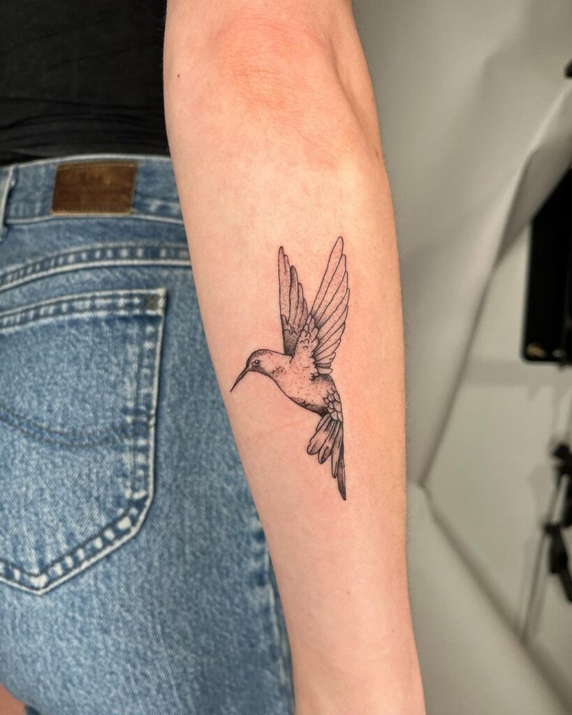 A fine-line hummingbird tattoo