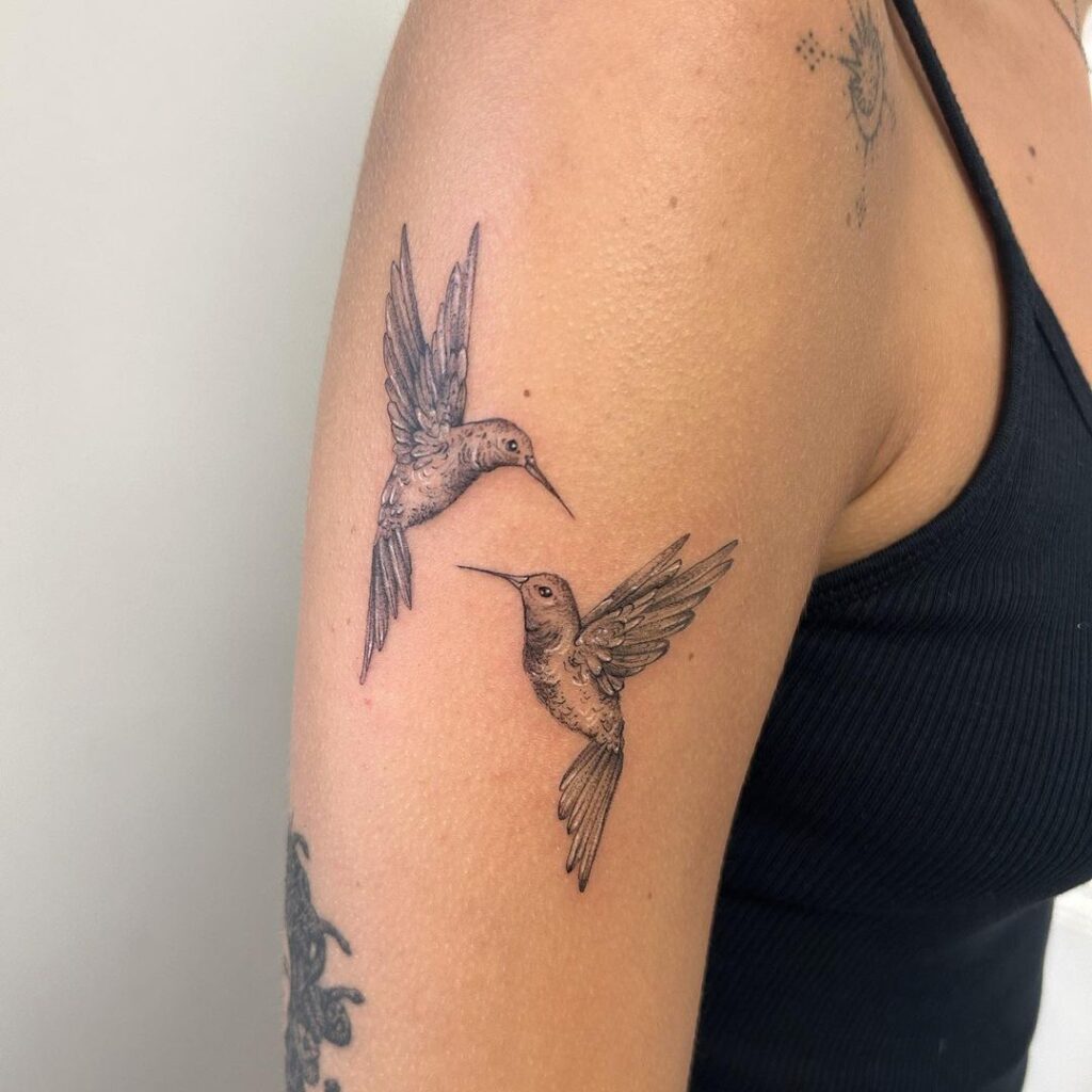 A hummingbird bird tattoo on the upper arm