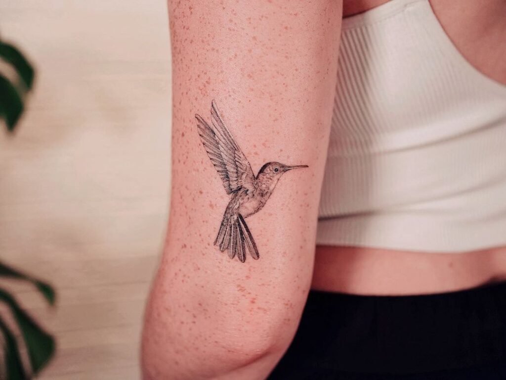 A hummingbird tattoo on the back of the arm