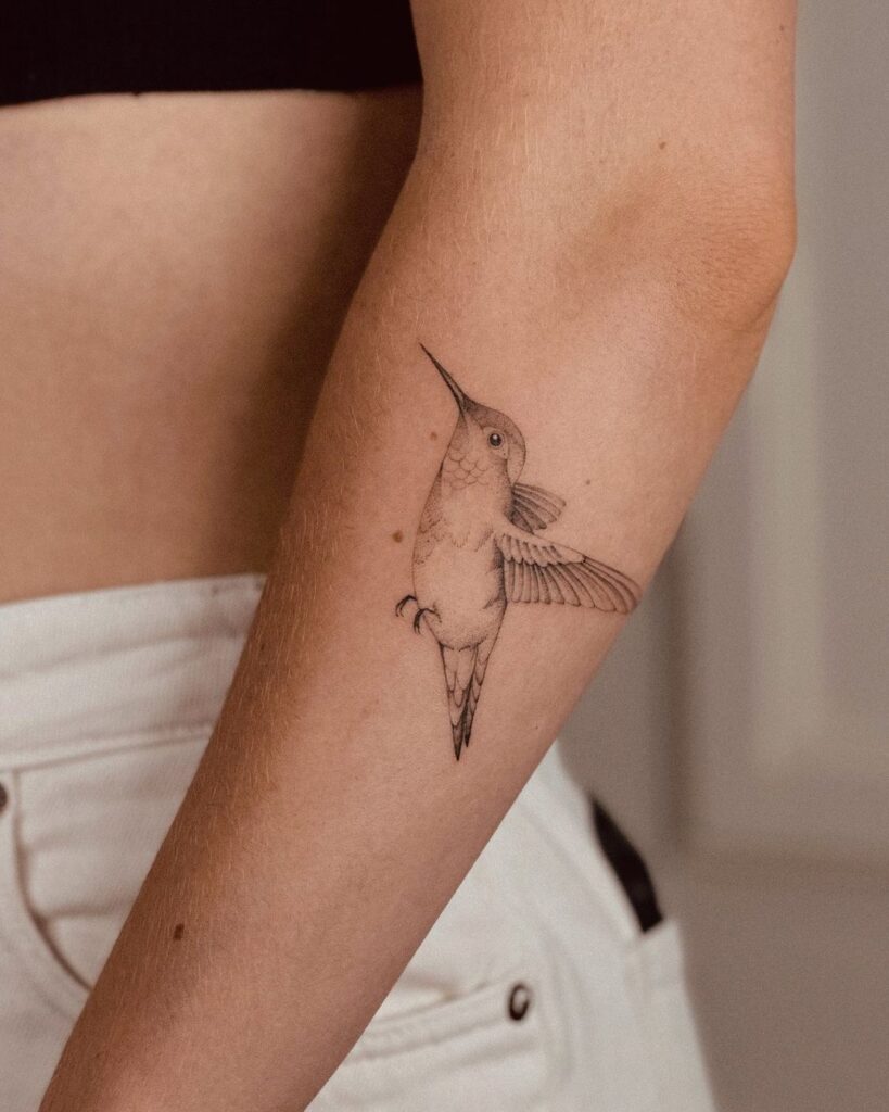 A hummingbird tattoo on the forearm