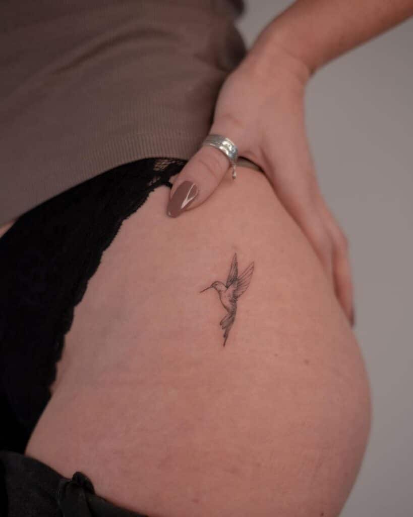 A hummingbird tattoo on the hip