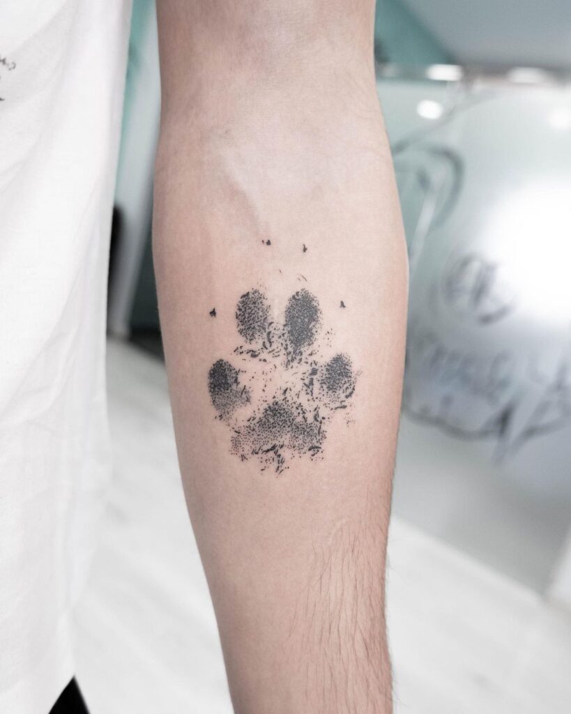 A paw print tattoo on the inside of the arm