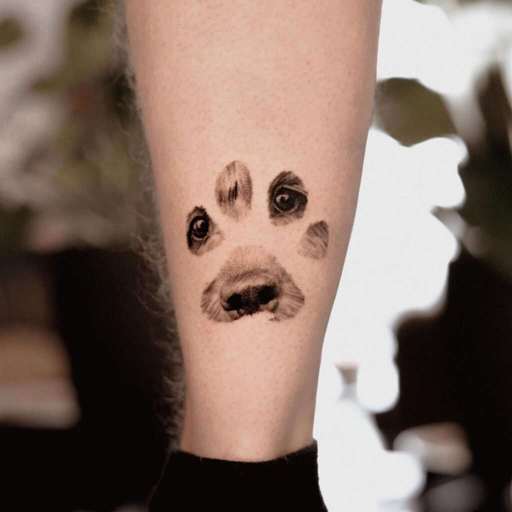 A puppy paw tattoo with a face