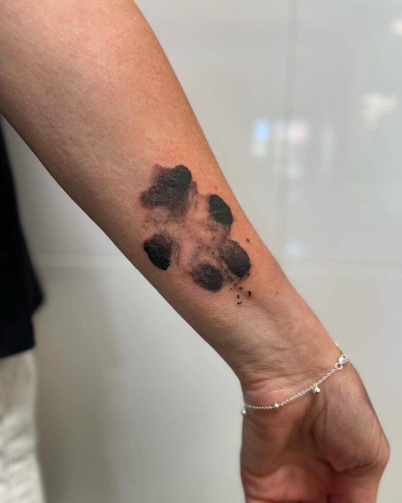 A splatter-style tattoo of a paw print