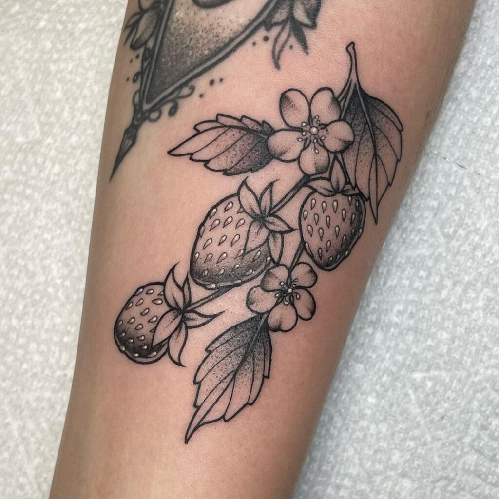 Black and gray strawberry tattoo on hand