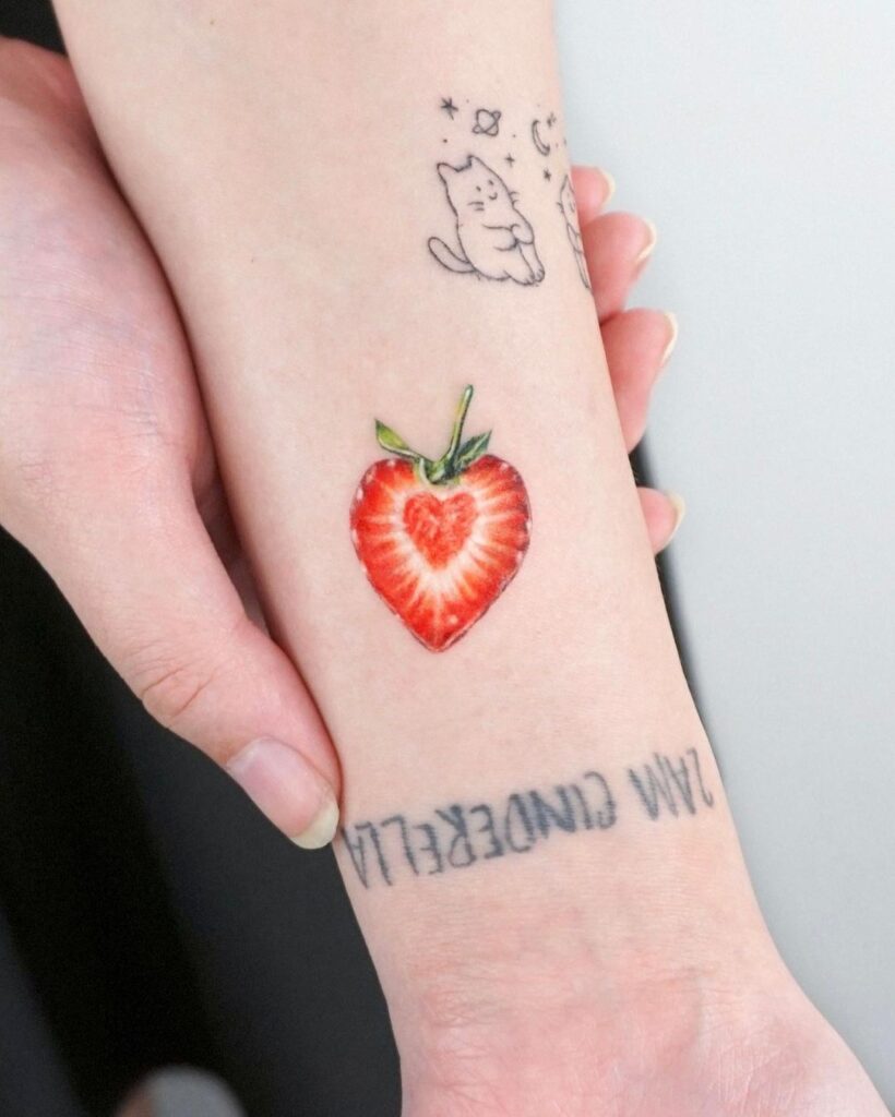 Half a strawberry colorful tattoo on hand