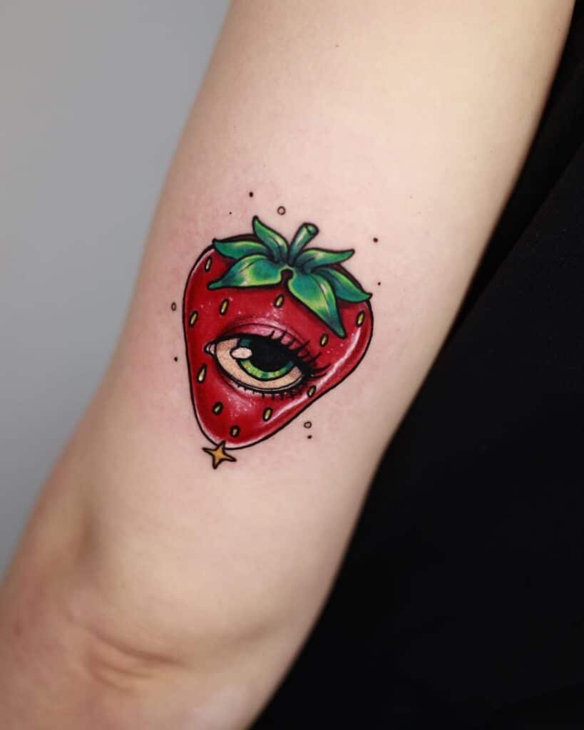 Strawberry eye tattoo on hand